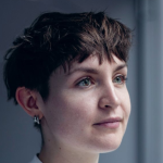 A photograph of El Reid-Buckley in Ormston House. They have short, dark hair.