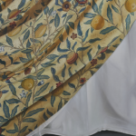 A painting of a cloth, with a pattern of flowers and fruit, draped over another plain white cloth.