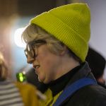 A photograph of Tiffany Glenn at an event in Ormston House. She has short, blonde hair and wears glasses and a yellow beanie.