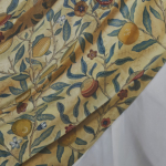A painting of a cloth, with a pattern of flowers and fruit, draped over another plain white cloth.